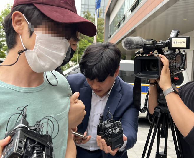 연인 폭행으로 신고 당한 뒤 경찰 조사를 마친 직후 애인을 살해한 혐의를 받는 김아무개(33)씨가 5월26일 오후 경찰에 긴급체포된 후 서울 금천경찰서에 들어서고 있다. ⓒ 연합뉴스