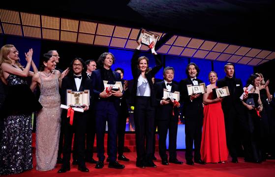 27일(현지시간) 개최된 제76회 칸국제영화제 폐막식에서 올해의 수상자들이 무대에 올라 기쁨을 나누고 있다. 〈사진=AFP·연합뉴스〉