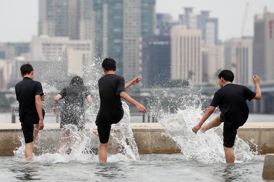 전국 대부분이 초여름 날씨를 보인 지난 24일 서울 여의도 물빛광장을 찾은 학생들이 물놀이를 하고 있다. 뉴스1