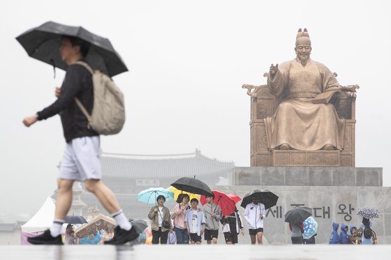 전국에 비가 내리는 28일 서울 광화문광장을 찾은 시민들이 우산을 쓰고 이동하고 있다.  사진 뉴스1