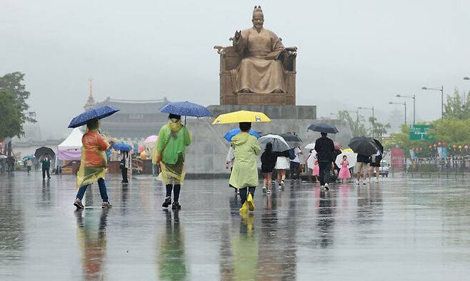 28일 서울 세종대로 광화문광장에서 우산을 쓰고 우비를 입은 시민과 관광객들이 오가고 있다. 연합뉴스