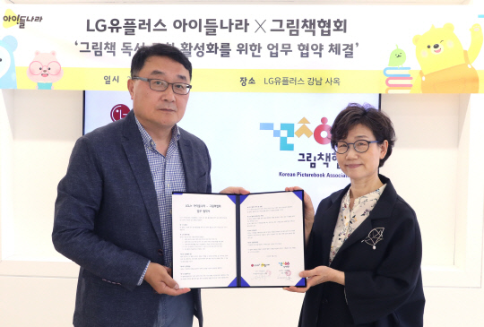 LG유플러스 박종욱(왼쪽) 아이들나라CO와 그림책협회 이영경 회장이 업무협약을 맺고 기념 사진을 촬영하고 있다. LG유플러스 제공