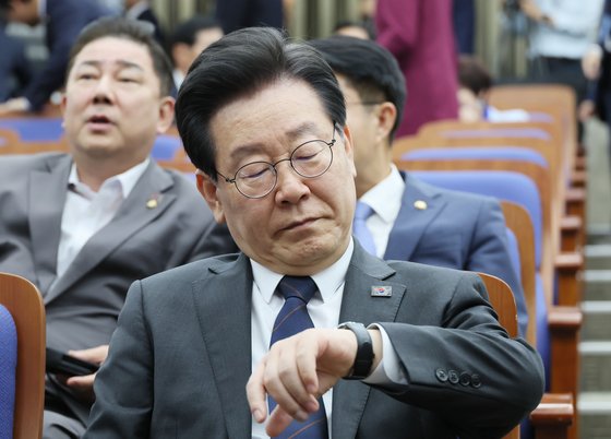 더불어민주당 이재명 대표가 25일 오후 국회에서 열린 의원총회에서 시간을 확인하고 있다. 연합뉴스