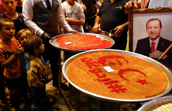 튀르키예 대선 결선 투표가 열린 28일(현지시간) 팔레스타인 가자 지구에서 레제프 타이이프 에르도안 튀르키예 대통령을 지지하는 팔레스타인인들과 아이들이 모여 케이크를 기다리고 있다. 로이터연합뉴스