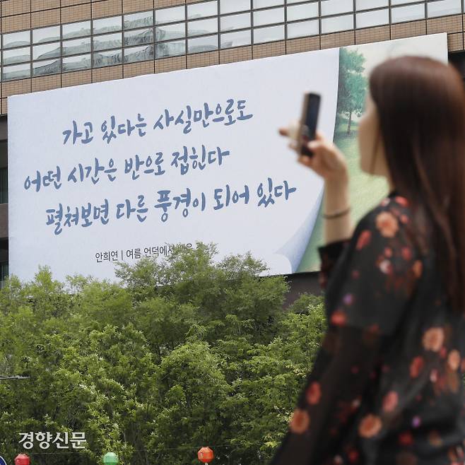 교보생명 광화문글판 여름 편이 안희연 시인의 시 ‘여름 언덕에서 배운 것’에서 발췌한 내용으로 새롭게 단장한 30일 한 시민이 글판을 카메라에 담고 있다. 문재원 기자