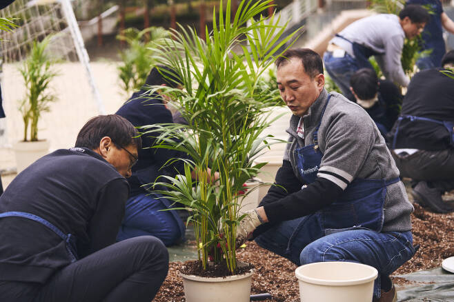 현대모비스 임직원들이 교실 숲 프로젝트 일환으로 직접 키운 공기정화 식물을 교실에서 분갈이하고 있다.