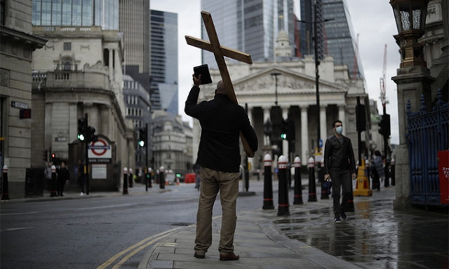 한 남성이 영국 런던에서 십자가와 성경을 들고 설교하는 모습. AP연합뉴스