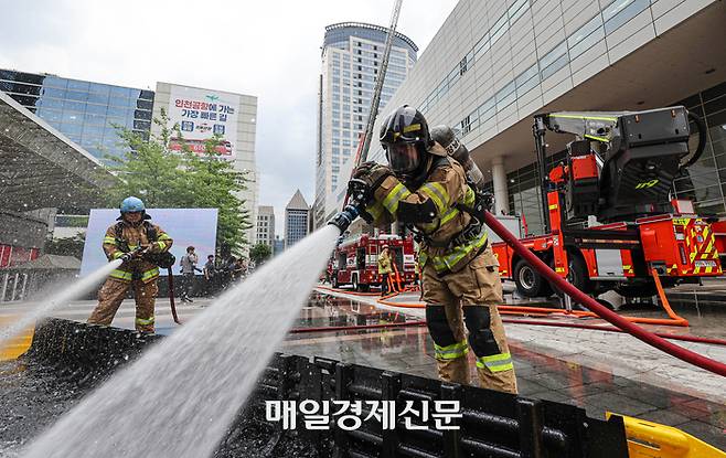 30일 오후 서울 강남구 코엑스 일대에서 열린 ‘2023년 재난대비 안전강남훈련’에서 소방관들이 전기차 화재 진압 시범을 보이고 있다. 코엑스에 드론을 이용한 생물테러와 대형 화재 발생을 가정해 진행된 이날 훈련에는 소방당국과 군·경 특수부대가 투입됐다. 2023.05.30 [박형기기자]