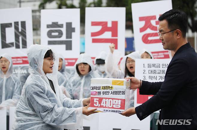 [서울=뉴시스] 김진아 기자 = 전국대학학생회네트워크가 28일 서울 용산구 대통령 집무실 앞에서 열린 '2023 대학생 3대 문제 해결을 위한 공동행동 : 등록금·생활비·구조조정, 대학생 재정난 해결을 위한 서명 전달 기자회견'에서 서명서를 대통령실 관계자에게 전달하고 있다. 2023.05.28. bluesoda@newsis.com