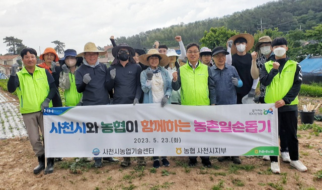 NH농협 경남 사천시지부와 사천시농업기술센터 직원들이 23일 사천시 향촌동 일대 마늘·양파 농가를 찾아 농촌 일손돕기를 하고 있다.