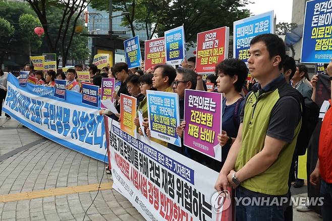 건정심회의장 앞 기자회견 하는 의료,시민 단체 (서울=연합뉴스) 최재구 기자 = 30일 서울 서초구 국제전자센터 대회의실에서 제9차 건강보험정책심의위원회가 열렸다. 비대면 진료 등에 반대하는 약사회 등 의료단체, 시민사회 단체 회원들이 회의장 앞에서 기자회견을 하고 있다. 2023.5.30 jjaeck9@yna.co.kr