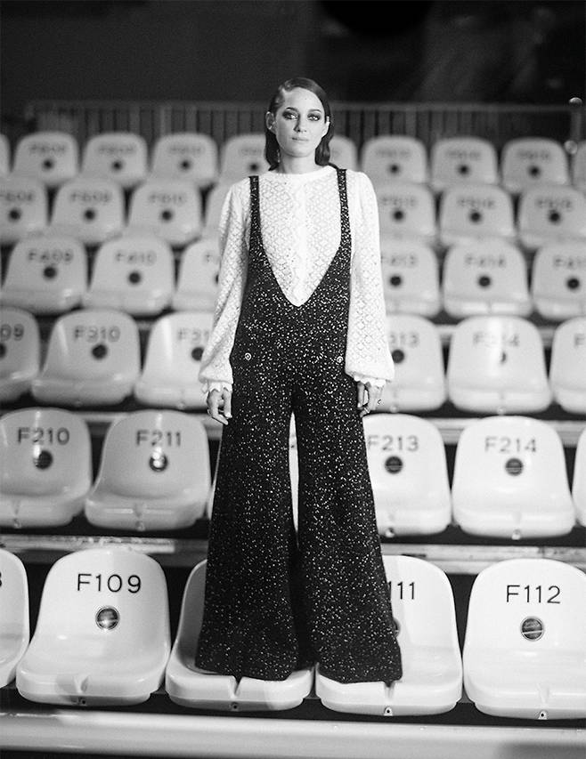 마리옹 꼬띠아르는 화이트 레이스 톱과 블랙 오버올 차림으로 등장했다.