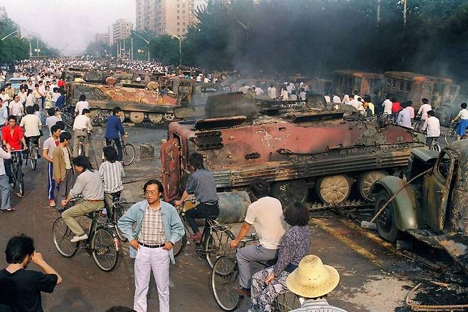 6월4일: 한 시민이 광장에서 불에 탄 장갑차 20여 대 중 한 대의 내부를 살펴보고 있다. AFP 연합뉴스