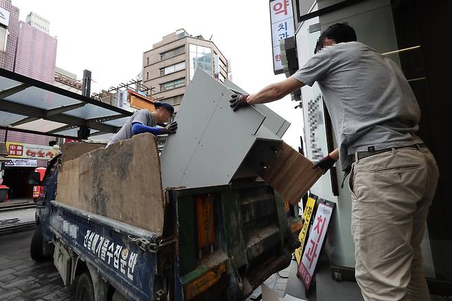 지난 29일 서울의 한 미술학원이 폐업하자 폐기물 수집 업체 직원들이 철거 작업을 하고 있다.   연합뉴스