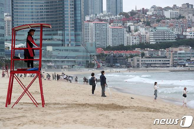 부산 해운대·송정해수욕장이 부분 개장한 1일 해운대해수욕장에 설치된 망루에서 민간 수상구조대원이 물놀이를 즐기는 관광객들을 지켜보고 있다. 부산 7개 해수욕장 전면 개장은 다음달 1일이다. 2023.6.1/뉴스1 ⓒ News1 윤일지 기자