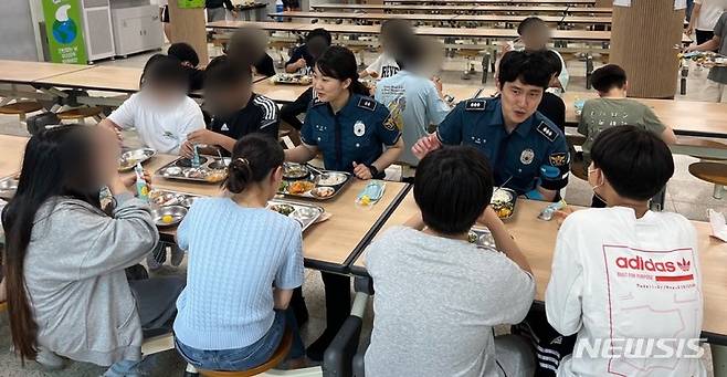 [인천=뉴시스] 인천 서부경찰서 학교전담경찰관들이 1일 인천해원초등학교 급식실에서 학생들과 점심을 먹고 있다. (사진=서부서 제공)