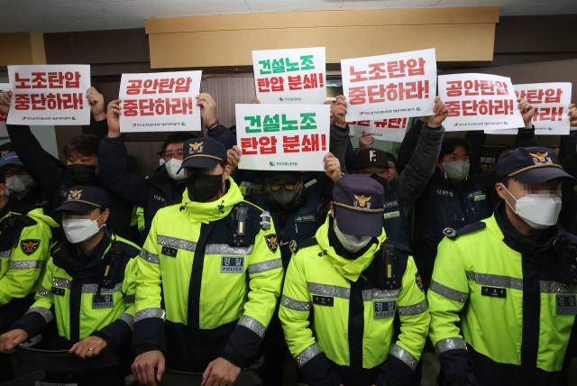 ▲민주노총 건설노조 조합원들이 19일 오전 압수수색이 진행되고 있는 서울 영등포구 민주노총 건설노조 서울경기북부지부 사무실 앞에서 손팻말을 들고 있다. 서울경찰청 강력범죄수사대는 이날 오전부터 건설현장 불법행위와 관련해 양대노총 건설노조를 압수수색하고 있다. ⓒ연합뉴스