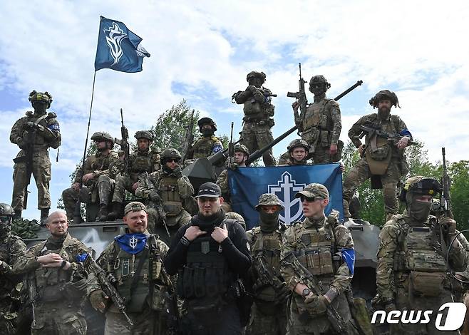 24일(현지시간) 러시아 국경과 인접한 우크라이나 북부에서 '화이트 렉스'라는 별명으로 알려진 반푸틴 성향의 무장단체 '러시아 자원봉사단(RVC)'이 포즈를 취하고 있다. 이들은 이날 러시아령 크름반도의 벨고로드를 공격한 것이 자신들의 소행이라고 주장했다. 2023.05.24/ ⓒ AFP=뉴스1 ⓒ News1 권진영 기자
