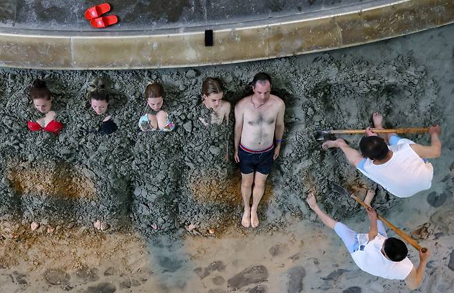 2023년 5월 22일 중국 랴오닝성 안산의 탕강지 스파 리조트에서 러시아 관광객들이 머드 테라피를 받고 있다. 코로나19 팬데믹으로 인해 2020년 중단됐던 러시아 연해주와 중국 간의 관광 교류가 1월 8일부터  재개된 가운데 중국은 러시아와 무비자 단체 여행 협정을 갱신했다./TASS 연합뉴스