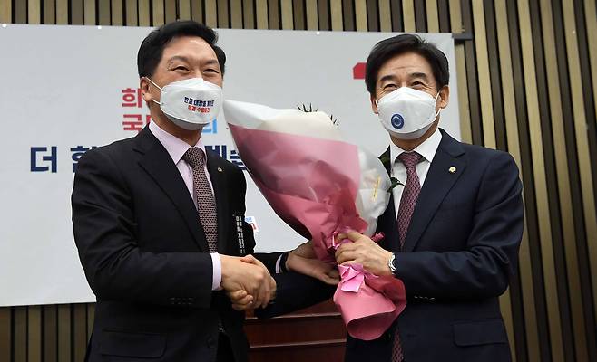 2021년 12월 9일 서울 여의도 국회에서 열린 국민의힘 의총에서 김기현 원내대표가 국민의힘에 입당한 이용호 의원에게 꽃다발을 전달하고 있다. /뉴스1