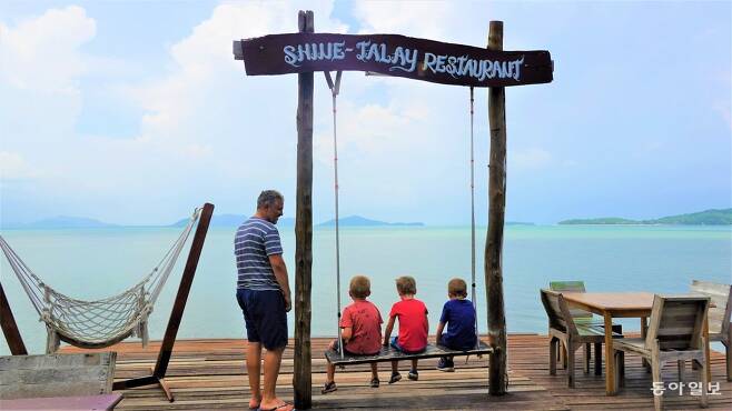 란따섬 올드 타운의 해산물 레스토랑. 해산물을 조리하는 동안 어린이 관광객들이 그네에 앉아 바다 구경을 하고 있다.