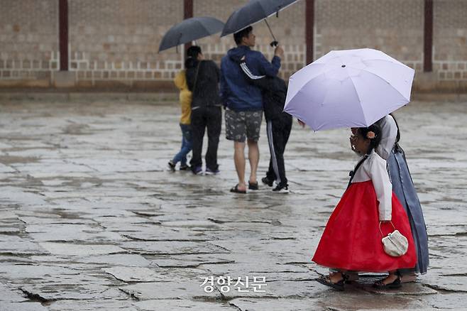 지난달 28일 서울 종로구 경복궁에서 관광객들이 우산을 쓴 채 관람을 하고 있다. 문재원 기자