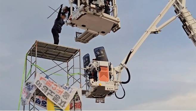 전남경찰이 5월 31일 광양제철소 포스코복지재단 앞 도로에서 고공농성 중이던 한국노종 금속노련 간부를 현장에서 제압하며 체포하고 있다.  전남경찰청 제공.