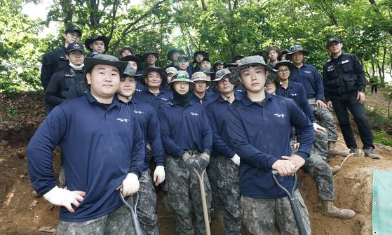 지난달 31일 오후 강원도 철원군 근남면 민통선 내 734고지에서 유해 발굴 중인 국방부 유해발굴감식단과 육군 제 15사단 50여단 2대대 장병들. 앞줄 왼쪽이 유해 발굴을 위해 전역을 미룬 양원식 병장, 오른쪽이 한국전쟁 백마고지 전투에서 큰할아버지를 잃은 양민재 병장이다. 최기웅 기자