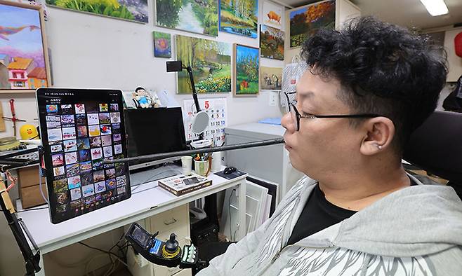 임 화가가 태블릿 PC로 사진을 보며 그림 아이디어를 얻고 있다.