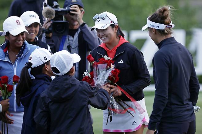 꽃에게 꽃을 - 로즈 장(오른쪽에서 둘째)이 5일 미국 뉴저지주 리버티 내셔널 골프클럽에서 연장전 끝에 LPGA 투어 미즈호 아메리카스 오픈 우승을 차지한 뒤 장미꽃을 선물받고 있다. /AP 연합뉴스