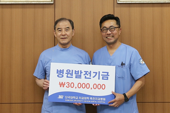 5일 홍찬의 석좌교수(왼쪽)이 정동화 단국대 죽전치과병원장에게 발전기금을 기부하고 있다. [사진=단국대]