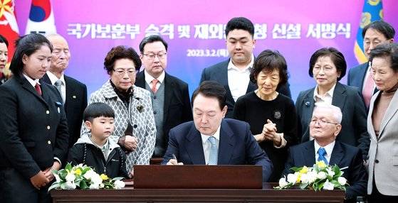 윤석열 대통령이 지난 3월 2일 서울 용산 대통령실 청사에서 국가보훈부 승격과 재외동포청 신설을 담은 개정 '정부조직법' 공포안에 서명하고 있다. 이 개정법에 따라 현충일을 하루 앞둔 6월 5일부터 국가보훈처는 국가보훈부로 승격되고, 외교부 산하에 재외동포청도 같은날 출범한다. [대통령실통신사진기자단]