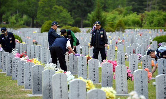 국립대전현충원 장병묘역을 찾은 대한민국월남전참전자회 용사들이 먼저 떠난 전우들의 묘비를 닦으며 예를 표하고 있다. [사진 김성태 프리랜서]
