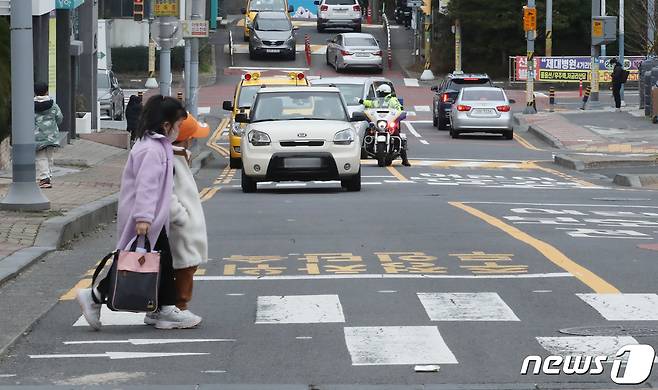 제주경찰이 9일 오후 제주시 이도초등학교 어린이보호구역에서 보행자 보호의무 위반 행위를 단속하고 있다. 개정 도로교통법에 따라 어린이 보호구역 내 신호기가 없는 횡단보도에서는 보행자 유무와 관계없이 일시정지해야 한다. 2023.2.9/뉴스1 ⓒ News1 오현지 기자