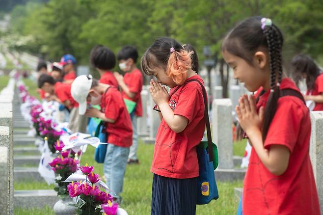 현충일을 하루 앞둔 5일 오전 동작구 서울 현충원을 찾은 어린이들이 6.25 전사자 묘소에서 참전 용사의 뜻을 기리며 기도하고 있다. /박상훈 기자