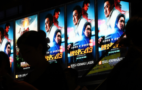 6일 서울 시내 한 극장에서 관람객들이 영화 '범죄도시 3' 홍보물 앞을 지나고 있다. 배급사 에비오엔터테인먼트에 따르면 '범죄도시 3'는 5일 오후 4시40분께 누적 관객 수 500만 명을 넘겼다. [연합뉴스]
