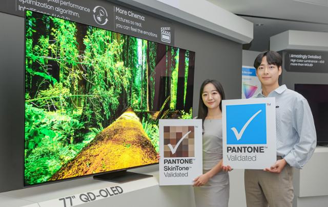 삼성디스플레이 직원들이 TV용 QD-OLED 앞에서 '팬톤 컬러 인증' 및 '팬톤 스킨톤 인증' 로고를 들고 기념촬영을 하고 있다. 삼성디스플레이 제공