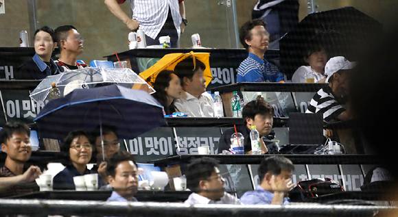 30일 서울 송파구 잠실야구장에서 열린 2023 프로야구 LG 트윈스 대 롯데 자이언츠의 경기에서 관중들이 동양하루살이를 피하기 위해 우산을 쓰고 있다.  [사진=뉴시스]