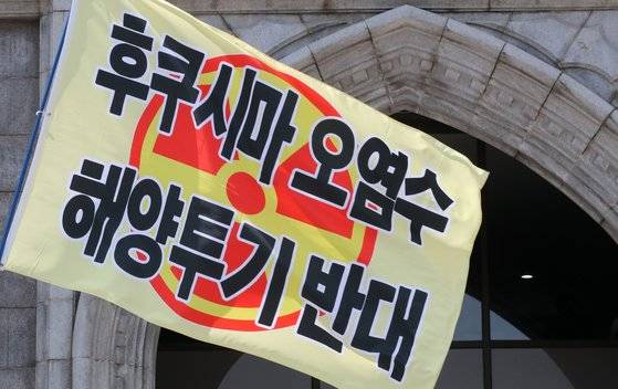 지난 5일 서울 성북구 안암동 고려대학교 인촌기념관에서 열린 한국환경회의 윤석열 정부의 생태학살 중단 촉구 기자회견에서 관계자가 깃발을 흔들고 있다. 뉴스1