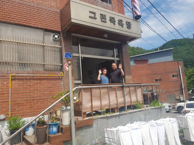 ▲ 그린목욕탕 2대 사장인 허태형 씨와 어머니 권춘자씨가 목욕탕 입구에서 손을 흔들고 있다.