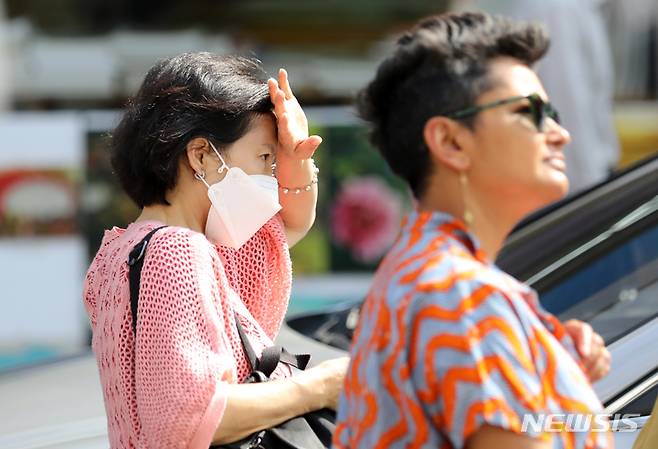 [서울=뉴시스] 김명년 기자 = 더운 날씨를 보인 5일 오후 서울 종로구 쌈지길에서 한 시민이 손으로 햇빛을 가린 채 이동하고 있다. 2023.06.05. kmn@newsis.com