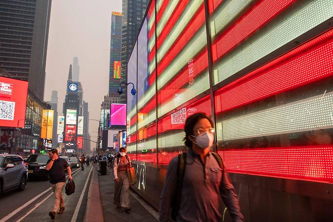 캐나다 산불 연기로 공기질지수(AQI)가 400에 육박하며 세계 최악을 기록한 뉴욕시 타임스퀘어의 7일 거리 풍경. 사람들은 모두 팬데믹 종료와 함께 처박아뒀던 마스크를 찾아 꺼내썼다.  /AFP 연합뉴스