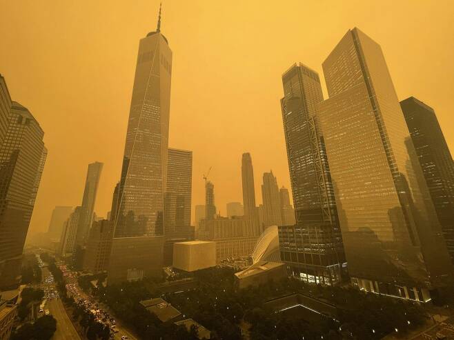 7일(현지시간) 캐나다 산불 여파로 미 뉴욕이 오렌지 연기로 뒤덮이며 세계 최악의 대기질을 기록했다. 사진은 뉴욕시 원 월드 트레이드센터 앞. 뉴욕=AP뉴시스