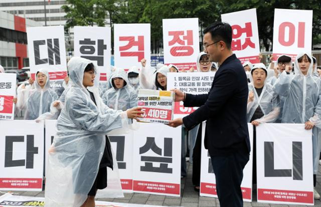 전국대학학생회네트워크가 지난달 28일 서울 용산구 대통령 집무실 앞에서 열린 '2023 대학생 3대 문제 해결을 위한 공동행동 : 등록금·생활비·구조조정, 대학생 재정난 해결을 위한 서명 전달 기자회견'에서 서명서를 대통령실 관계자에게 전달하고 있다. 뉴시스