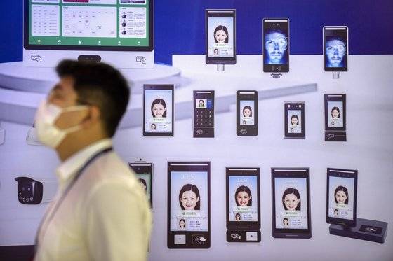 지난 4일 중국 베이징에서 열린 PT 엑스포에서 중국의 AI 얼굴인식 기술 광고 앞을 관람객이 지나고 있다. AP=연합뉴스