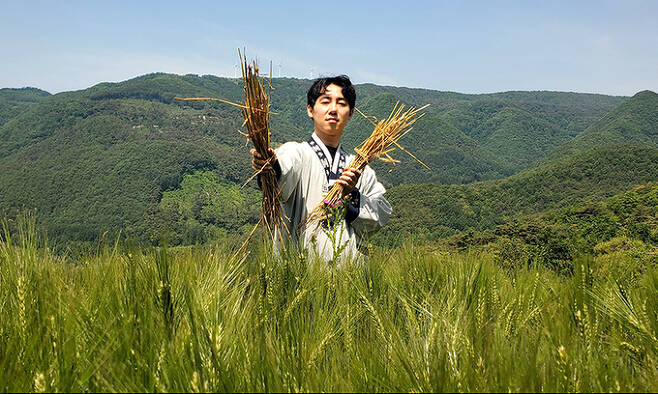 강원도 영월에서 보리 빨대를 만드는 ‘비어스’ 김인수 대표가 보리밭 앞에서 빨대 제작을 위해 건조한 보릿대를 들고 포즈를 취하고 있다.