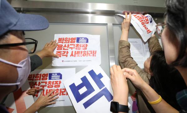 8일 오전 서울 용산구청에서 이태원 참사 유가족들이 보석으로 석방된 박희영 용산구청장의 출근을 저지하기 위해 구청장실 입구에 사퇴 촉구 손팻말을 붙이고 있다. 연합뉴스