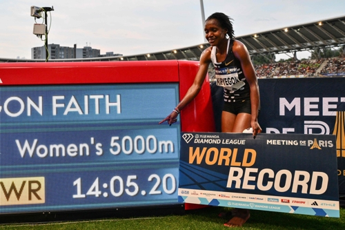 케냐의 페이스 키프예곤이 10일 프랑스 파리에서 열린 다이아몬드리그 여자 5000ｍ에서 14초05초20의 세계신기록으로 우승한 뒤 자신의 기록이 표시된 전관판 옆에서 사진을 찍고 있다. 파리|AFP연합뉴스