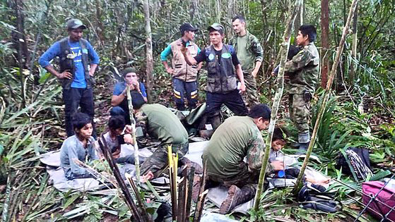 지난 9일(현지시간) 콜롬비아 아마존 정글에서 실종됐다 40만에 구조된 4남매가 수색대원들의 보호를 받고 있다. AP연합뉴스