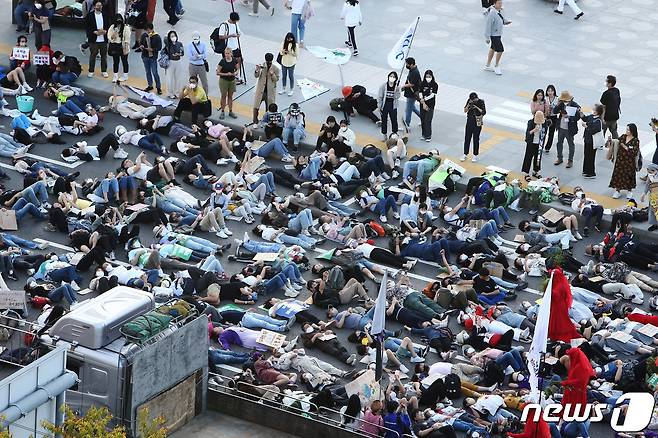 지난해 9월24일 환경단체 회원 등이 서울시청 인근 세종대로에서 화석 연료와 생명 파괴 체제 종식을 촉구하며 행진하던 중 기후위기를 경고하며 드러눕는 다이-인(Die-in) 시위를 하고 있다. ⓒ News1 조태형 기자